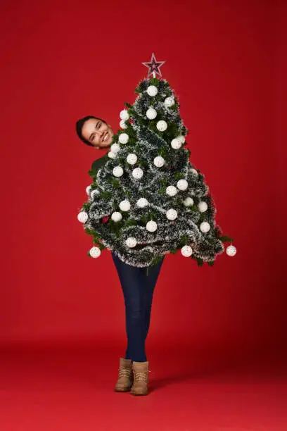 Photo of Girl holding Christmas tree