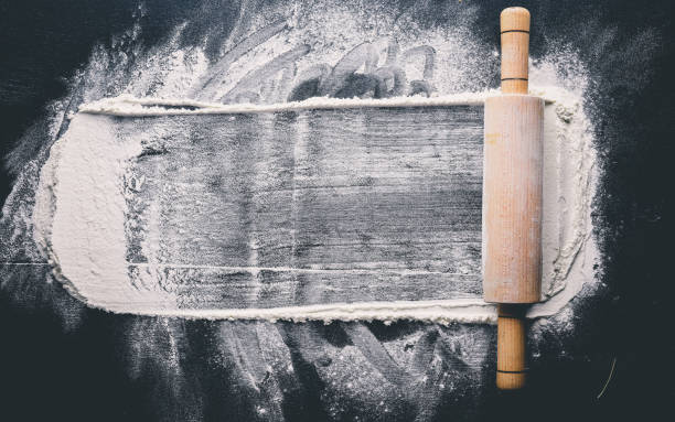 istock Rolling pin and white flour on a dark background. Free space for text . Top view. 873995986