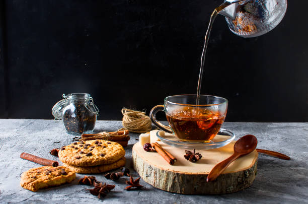 istock Cup of  tea, biscuits, cinnamon, anise on dark   background 874001692