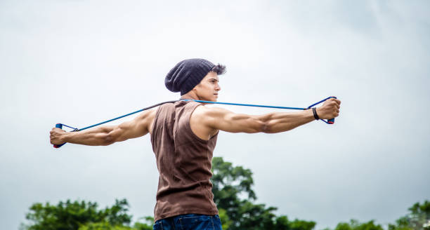 banda de resistencia estiramiento muscular hombre - aspirations men human arm arms outstretched fotografías e imágenes de stock