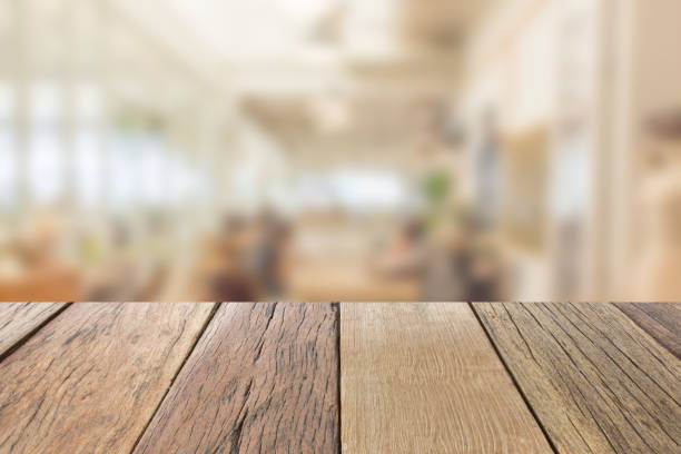 istock Empty wooden table top perspective with blur coffee shop background, used for montage or display your products. 874007420