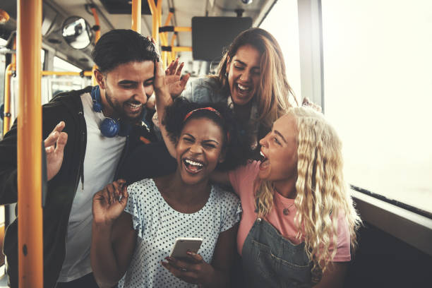 smiling diverse friends using a cellphone together on the bus - group of objects travel friendship women imagens e fotografias de stock