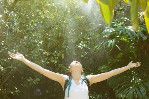 istock Female tourist with backpack under the rain in jungle. 874011246