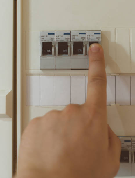 istock Male hand switching on fuse board. 874012892