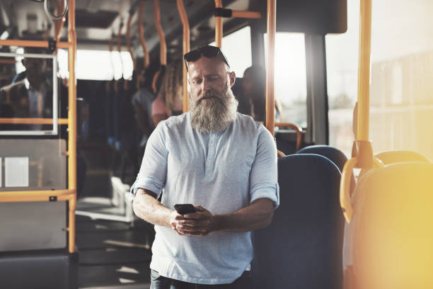 istock Mature man with a beard reading texts on the bus 874015460