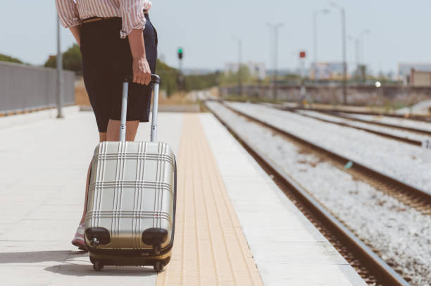 istock Woman with baggage is waiting for her train. 874015950
