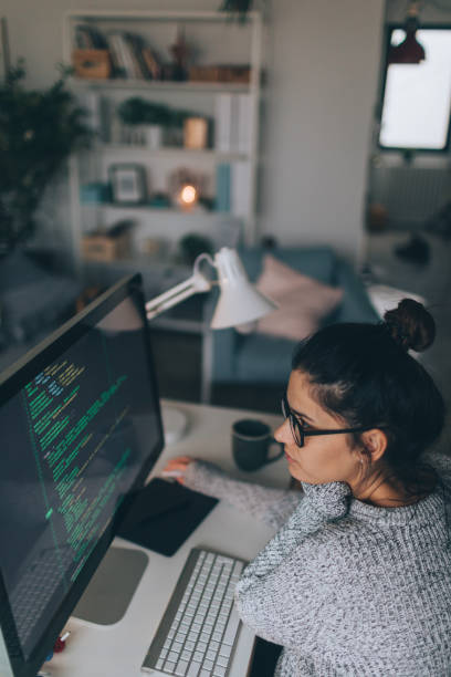 istock Young woman programming at her home office 874016260
