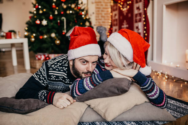 istock Christmas joy. Couple relaxing by the Christmas tree 874020234