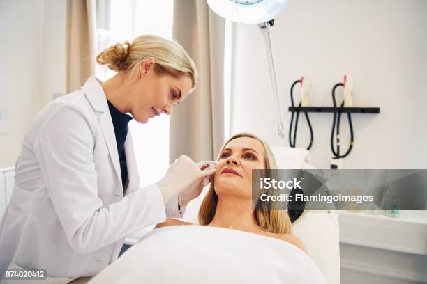 Arzt Botoxinjektionen Auf Eine Ältere Client Gesicht Zu Tun Stockfoto und mehr Bilder von Dermatologie