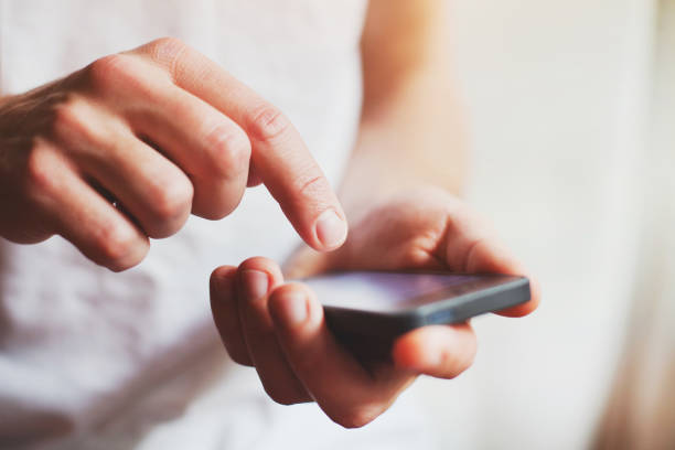 person using mobile application on smartphone person using mobile application on smartphone, abstract close up of hands clicking screen stock pictures, royalty-free photos & images