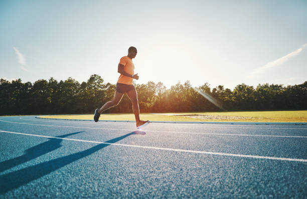 istock Fit young athlete running along a track in the afteroon 874030922