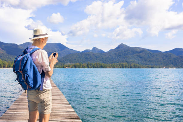 istock Female traveler with backpack checking smartphone while visiting travel destination 874031674