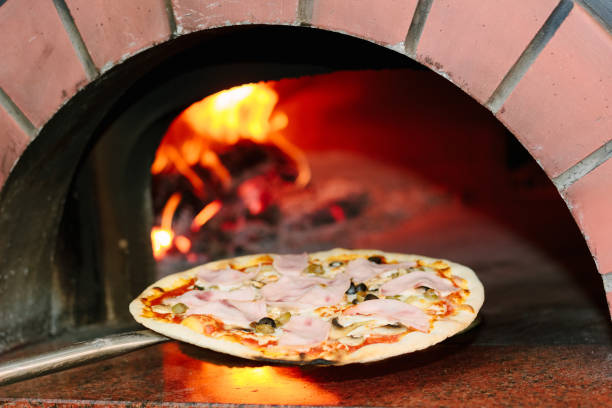 istock Chief taking pizza from the pizza oven 874041290