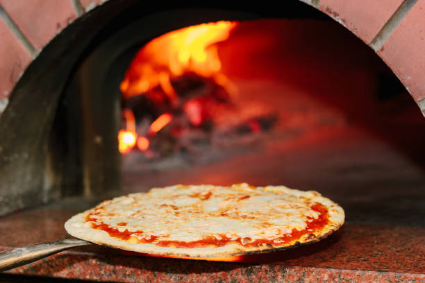 istock Chief taking pizza from the pizza oven 874041360