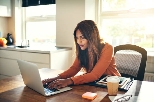 istock Young female entrepreneur working online in her home office 874046082