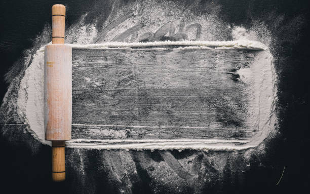 istock Rolling pin and white flour on a dark background. Free space for text . Top view. 874052012