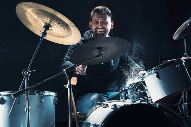 istock Drummer rehearsing on drums before rock concert. Man recording music on drum set in studio 874056310