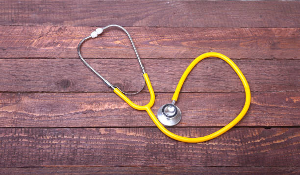 istock Medical stethoscope and tablets isolated on wooden background 874058932