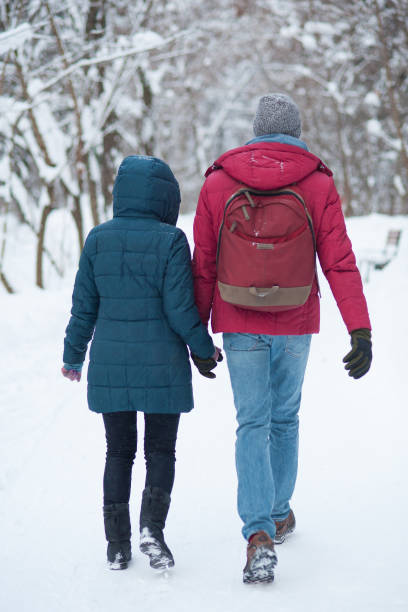 istock Young couple walking in winter park 874058992