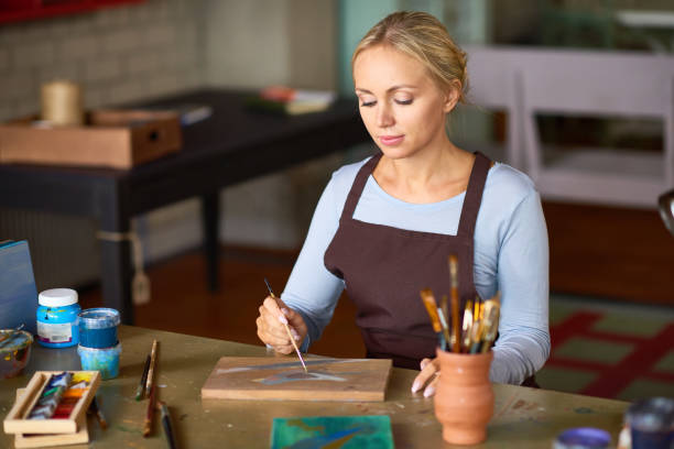 istock Beautiful Woman Painting in Art Studio 874060248