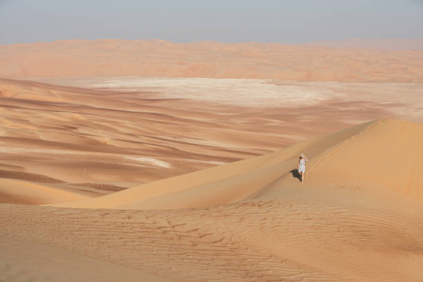 istock Young woman walking around desert. 874063116