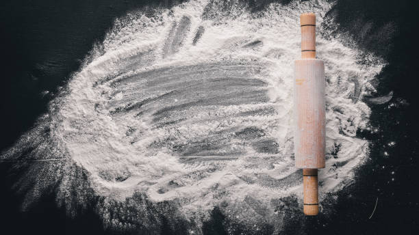 istock Rolling pin and white flour on a dark background. Free space for text . Top view. 874063444