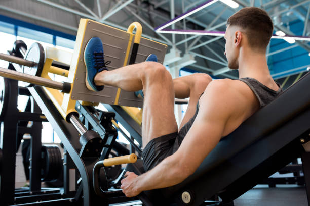 istock Modern Sportsman Training Legs in Gym 874067386