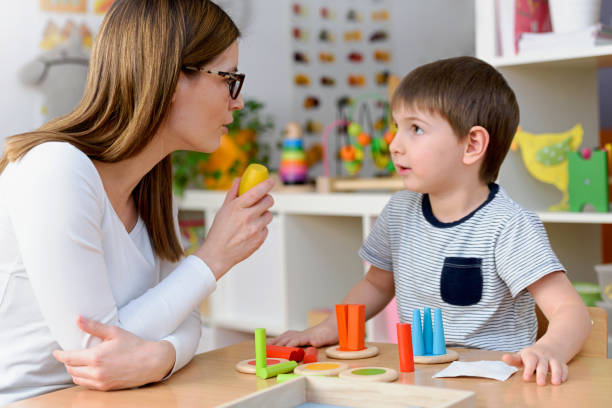 istock Kindergarten Teacher and Cute Boy Playing Educational Games in Classroom 874070766