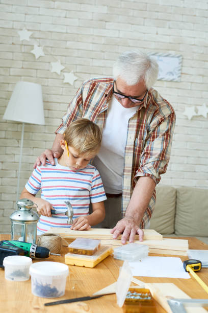 istock Grandfather Teaching Grandson Woodwork 874071552