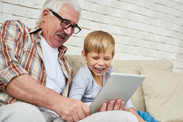 istock Happy Grandpa and Little Boy Using Digital Tablet 874071584