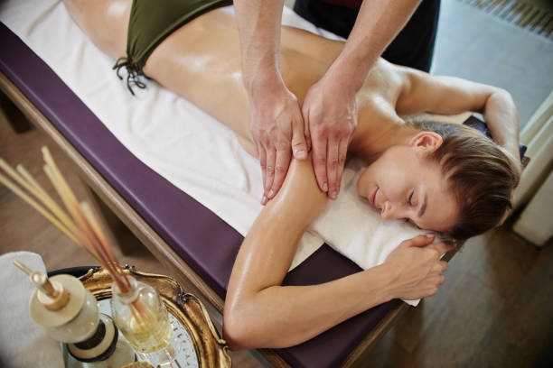 istock Male Masseuse Massaging Young Woman in SPA 874079410