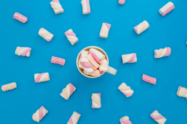 istock Cappuccino mug with marshmallows on blue background. Flat lay, top view 874079778