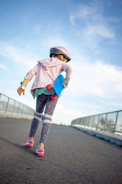 istock Little Girl Walking Away With Skateboard 874092464
