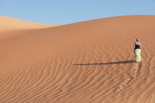 istock Young woman walking around desert. 874096354