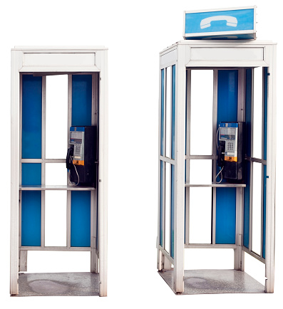 Two isolated blue and white vintage outdoor telephone booths.