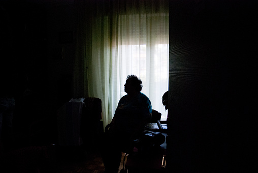 Senior mujer sola en el cuarto oscuro photo