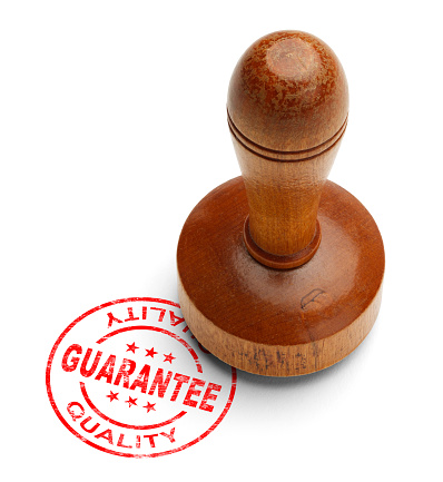 Red quality guarantee stamp with wooden stamper isolated on white background.