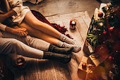 Couple holding hands and relaxing sitting under Christmas tree