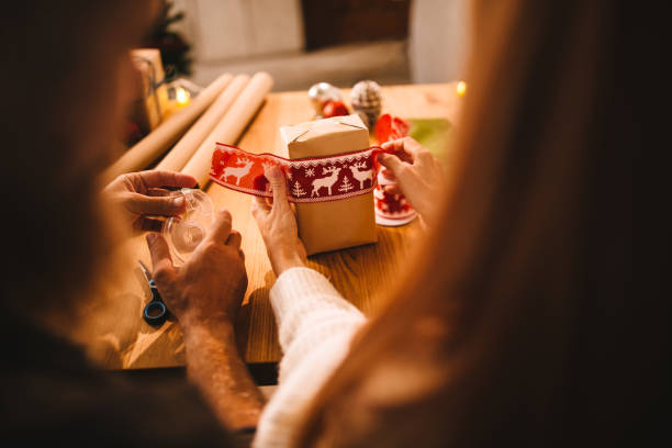남편과 아내는 가족을 위한 크리스마스 선물 포장 - gift ribbon straight wrapped 뉴스 사진 이미지