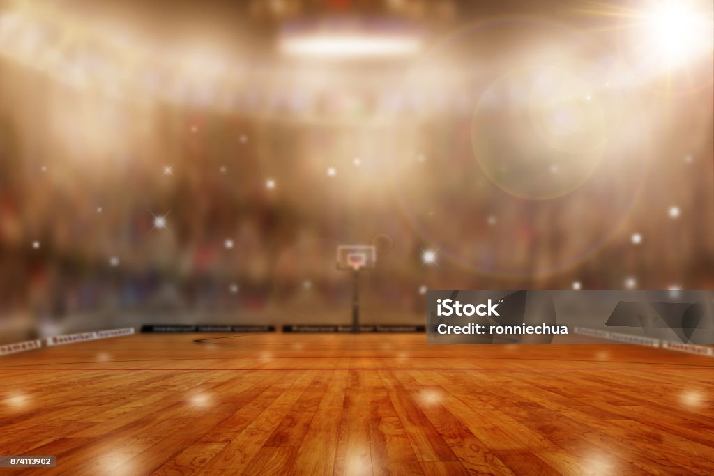 Basketball Arena With Copy Space Low angle view of fictitious basketball arena with flashes from sports fans in the stands and lens flare effect. Focus on foreground with deliberate shallow depth of field on background and copy space. Basketball - Sport Stock Photo