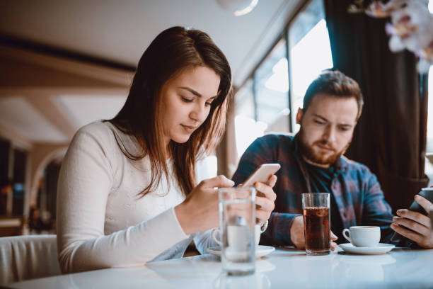 Couple with Rude Behaviour, Looking at Their Smartphone in a Cafe Couple with Rude Behaviour on Date in a Cafe couple on bad date stock pictures, royalty-free photos & images
