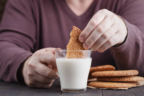 istock dunk sesame cookies biscuits in milk cup on table 874126514