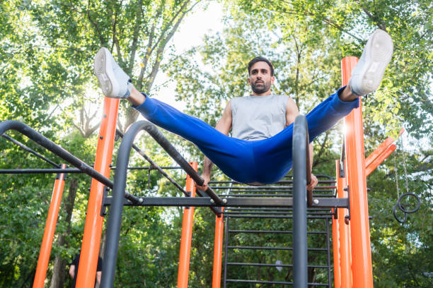 istock Handsome athletic young man exercising vertical leg raise in an 874129006