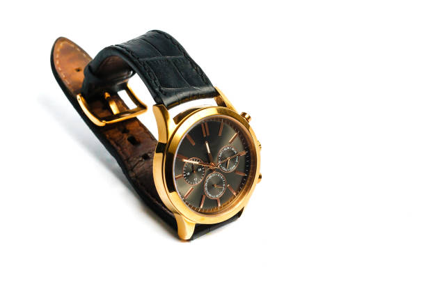 Gold wristwatch with a yellow metal bracelet on a dark blue background, separately