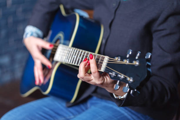 istock woman's hands playing acoustic guitar, close up 874156322