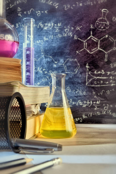 istock Classroom desk and drawn blackboard of chemistry teaching vertical 874157704