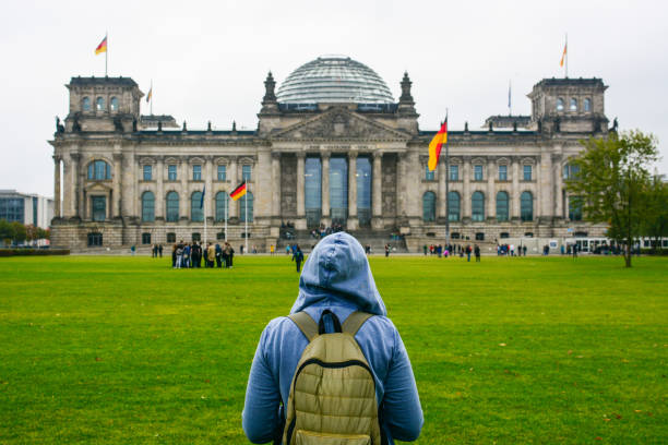istock Home away from Home: Young woman with backpack looking at Bundestag building 874160634