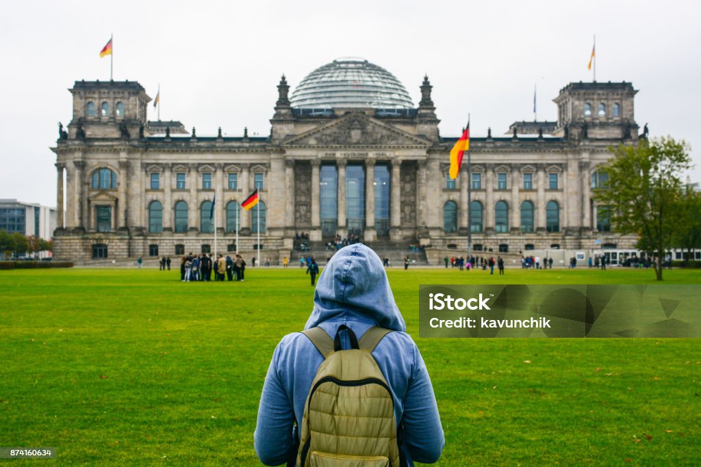 Home away from Home: Young woman with backpack looking at Bundestag building Young woman with backpack looking at Bundestag building in Berlin. Erasmus student, studying abroad and tourist concept. Berlin Stock Photo