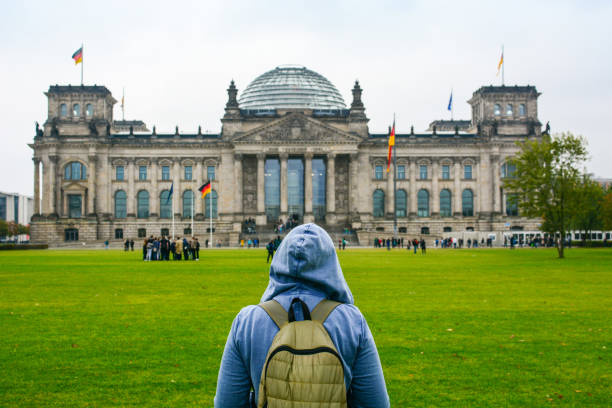 istock Home away from Home: Young woman with backpack looking at Bundestag building 874160644