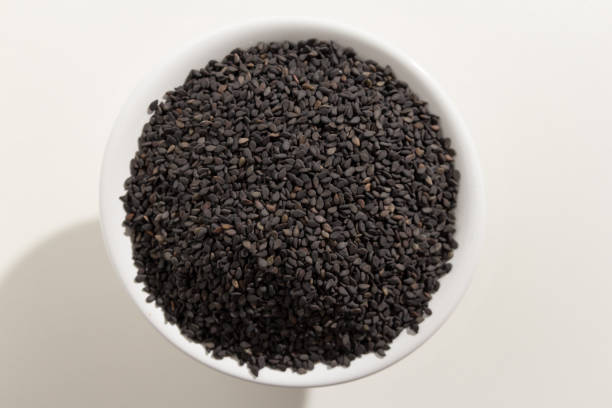 Sesamum radiatum is scientific name of Benniseed. Also known as Black Sesame, Gergelim Preto (portuguese) and Sesamo negro (spanish). Pile of grains, isolated white background. Top view of grains in a bowl. White background. sesamum radiatum es nombre científico de benniseed. también conocido como sésamo negro, gergelim preto (portugués) y la sésamo negro (español). montón de granos, fondo blanco aislado. vista superior de los granos en un recipiente. fondo blanco.